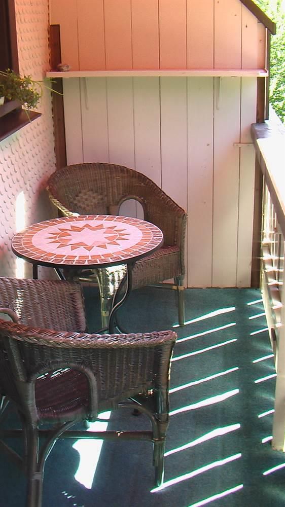 Balkon: Tisch mit Korbstühlen