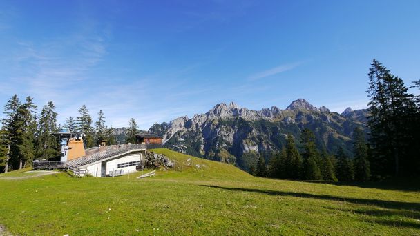 Die Bergstation der Doppelsesselbahn Krinnenalpe vor den bekannten Tannheimer Kletterbergen Rote Flüh, Gimpel und Köllenspitze