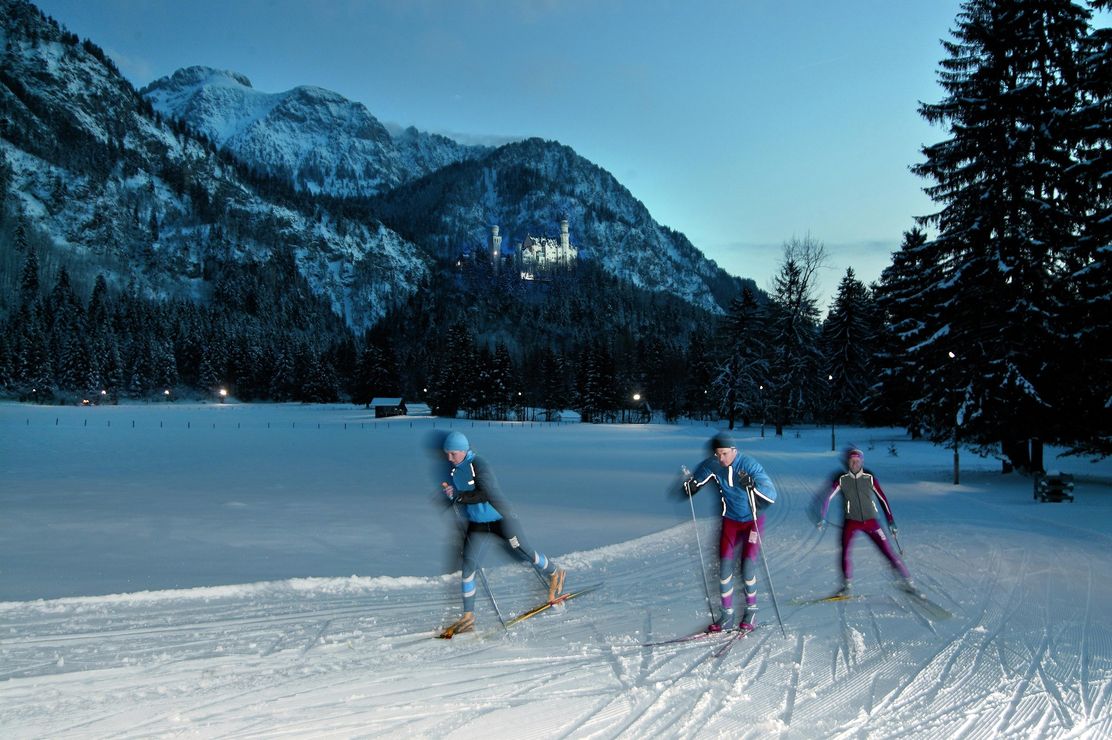 Flutlicht-Langlauf vor der Kulisse von Säuling und Schloß Neuschwanstein