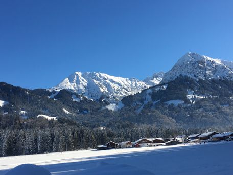 Blick auf die verschneite Landschaft und Allgäuer Alpen