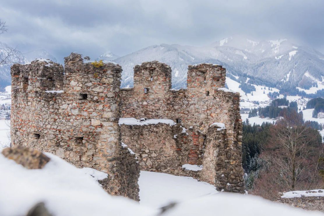 Burgruine in märchenhaft verschneiter Landschaft.