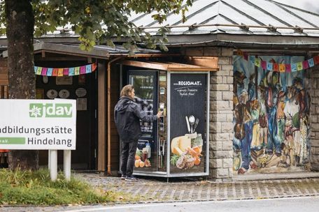 Junger Mann steht vor Automat