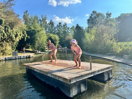 Das Bild zeigt ein Floß auf dem Wasserspielplatz, mit dem sich Kinder übers Wasser ziehen können