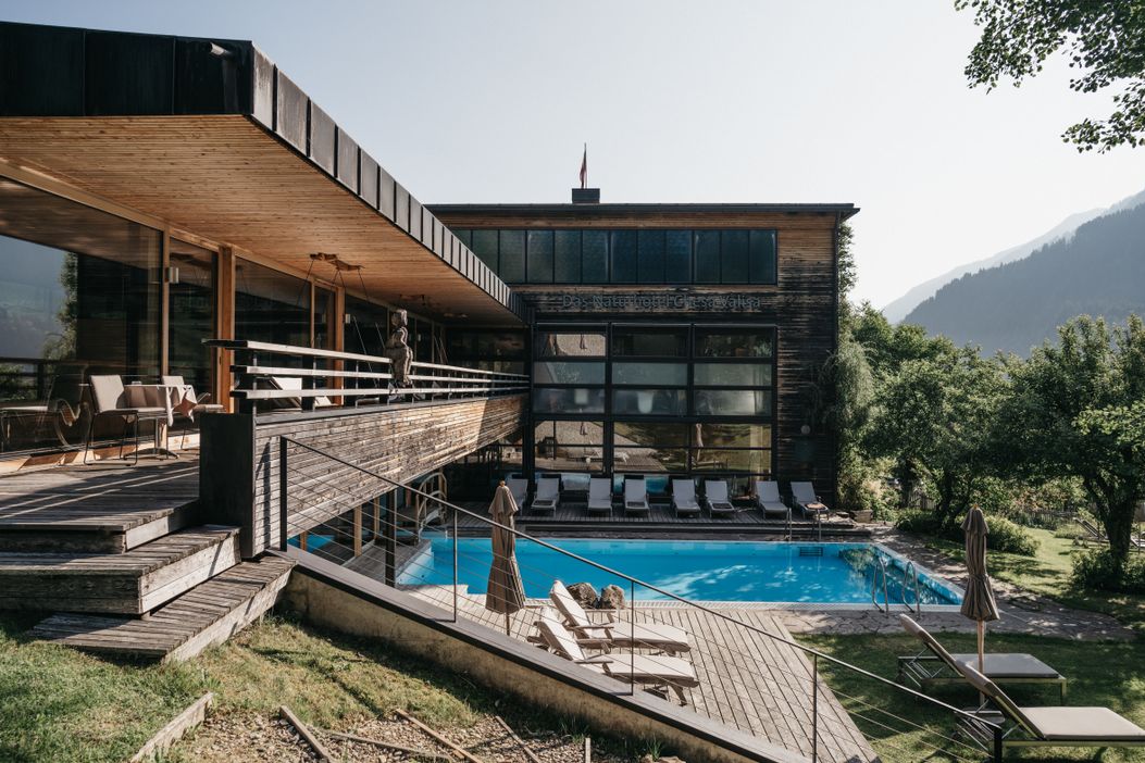 naturhotel_chesa_spa_outdoorpool_sommer_liegen_blick_hirschegg-hotel