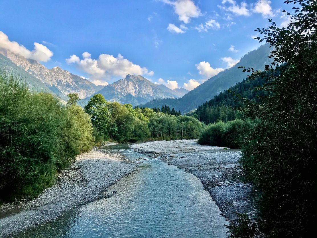 Der Ostrach-Fluss mit Bergen im Hintergrund