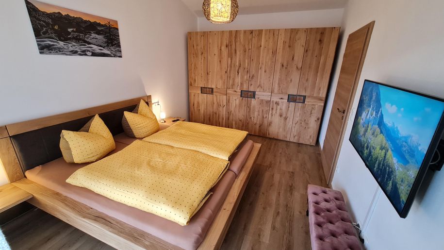 Alpines Schlafzimmer mit Doppelbett & Smart-TV