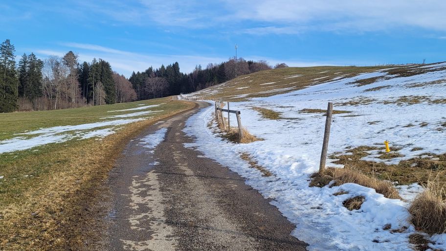 teils schneebedeckter Wegabschnitt oberhalb Bachtal